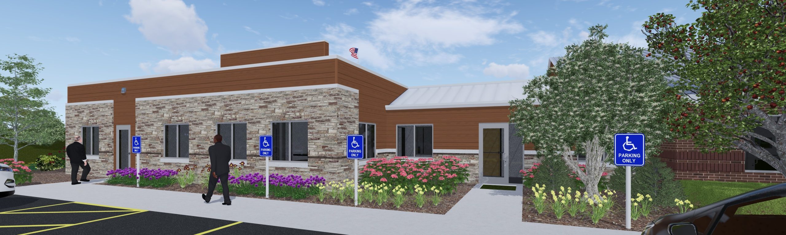 Modern commercial building exterior featuring stone and wood paneling, landscaped with colorful flowers, marked accessible parking spaces, and individuals approaching the entrance. Ideal for showcasing business services or community resources.